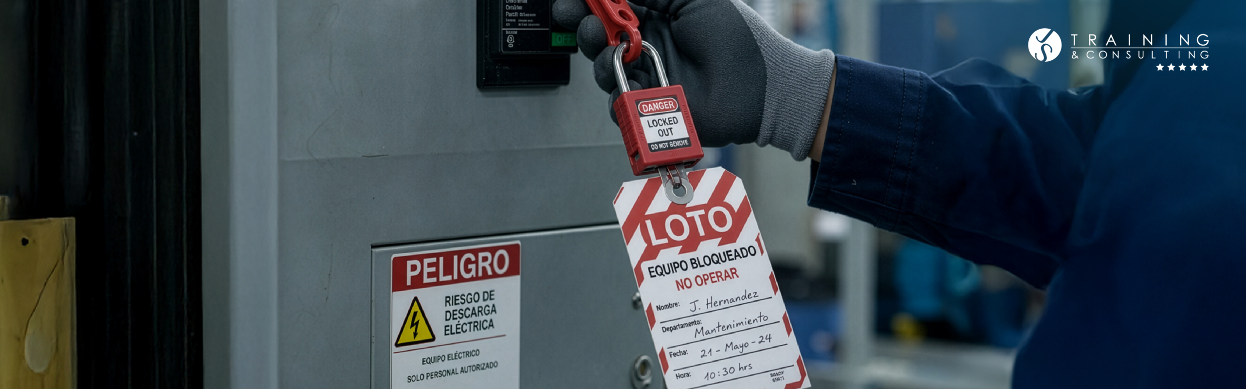 Primer plano detallado de una mano con guante de protección industrial colocando un candado rojo de seguridad con una etiqueta con los datos del operario "J. Hernández" en un panel de control con señales de advertencia.